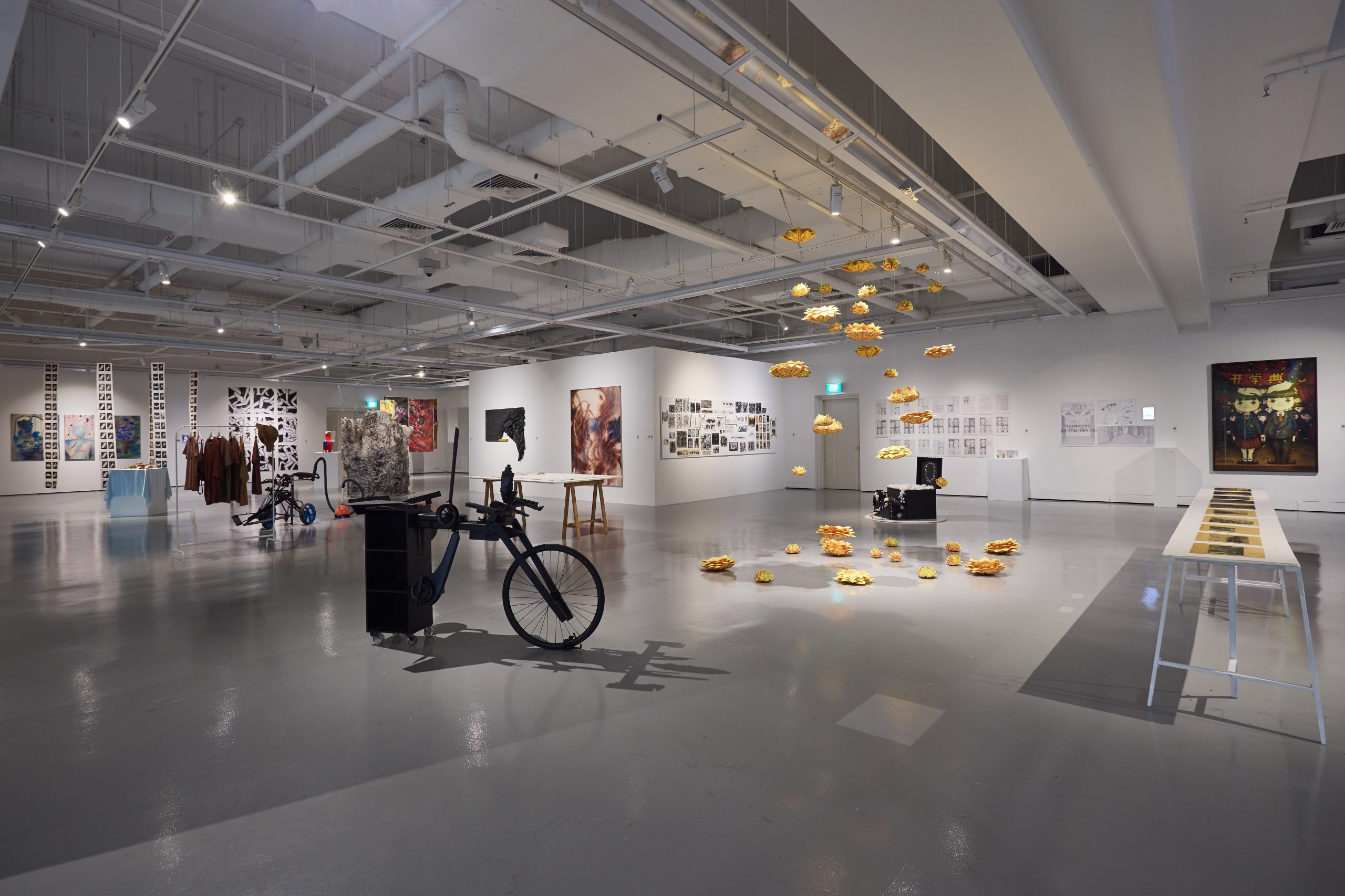 A contemporary gallery space showcasing interdisciplinary works from LASALLE students, including installations, sculpture, fashion, photography and mixed media.