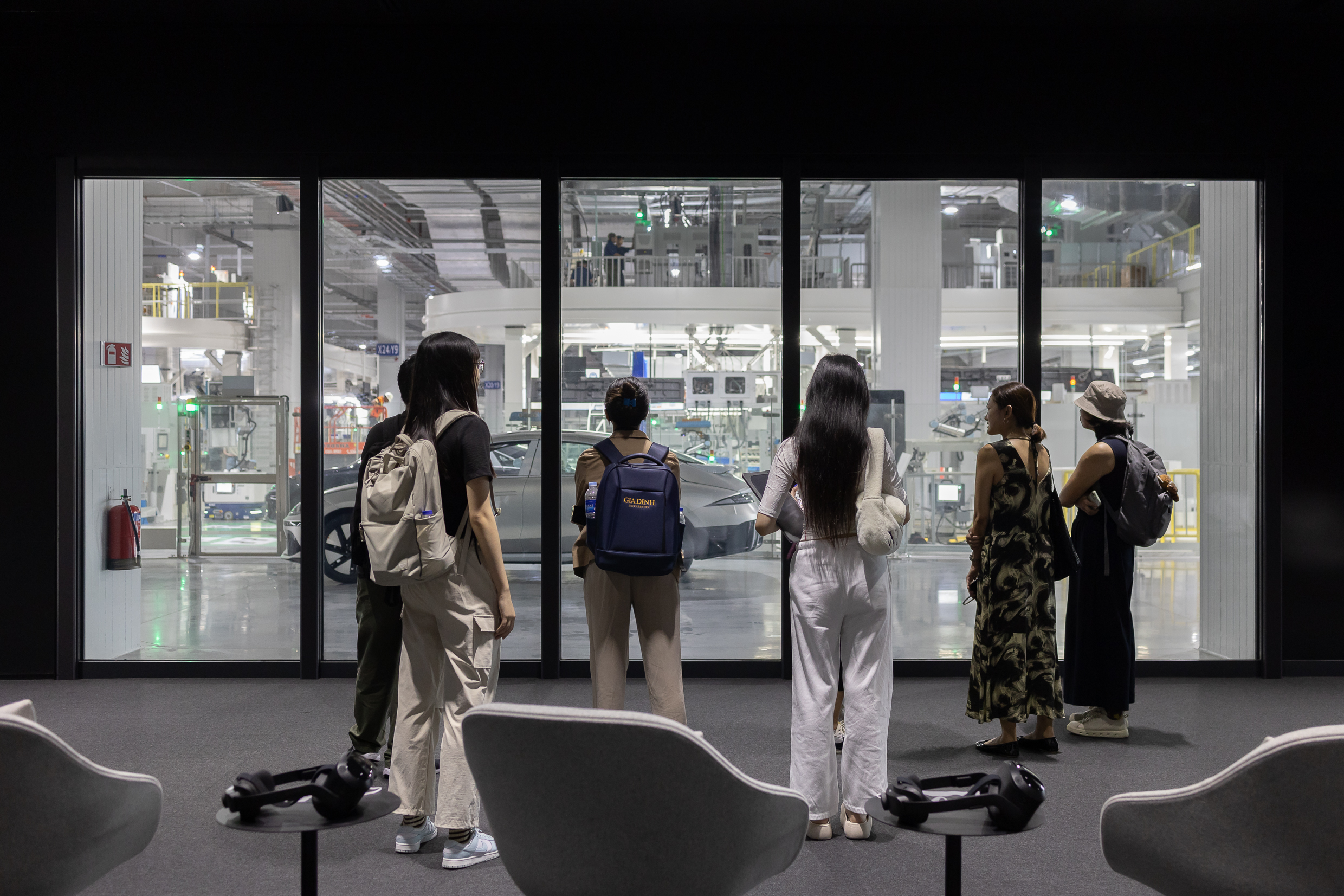 LASALLE students observing an advanced automotive manufacturing facility through glass during an industry visit and study tour.