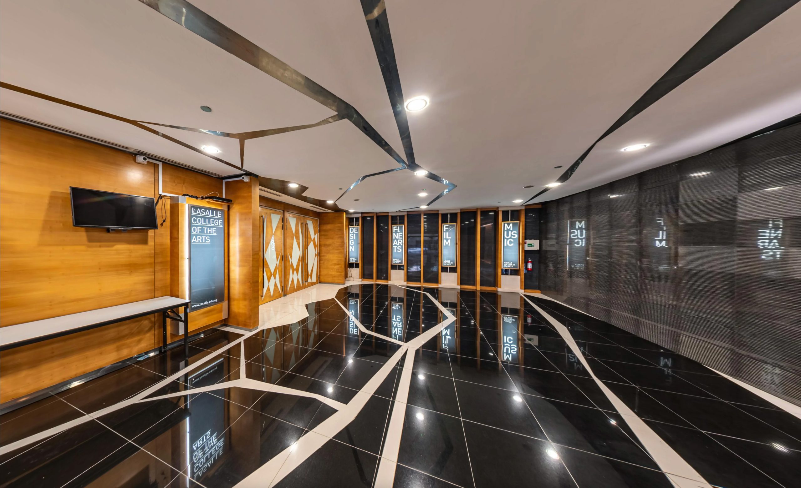 Stylised hallway with glossy black tile flooring, wood accents, display panels and mirrored ceiling features.